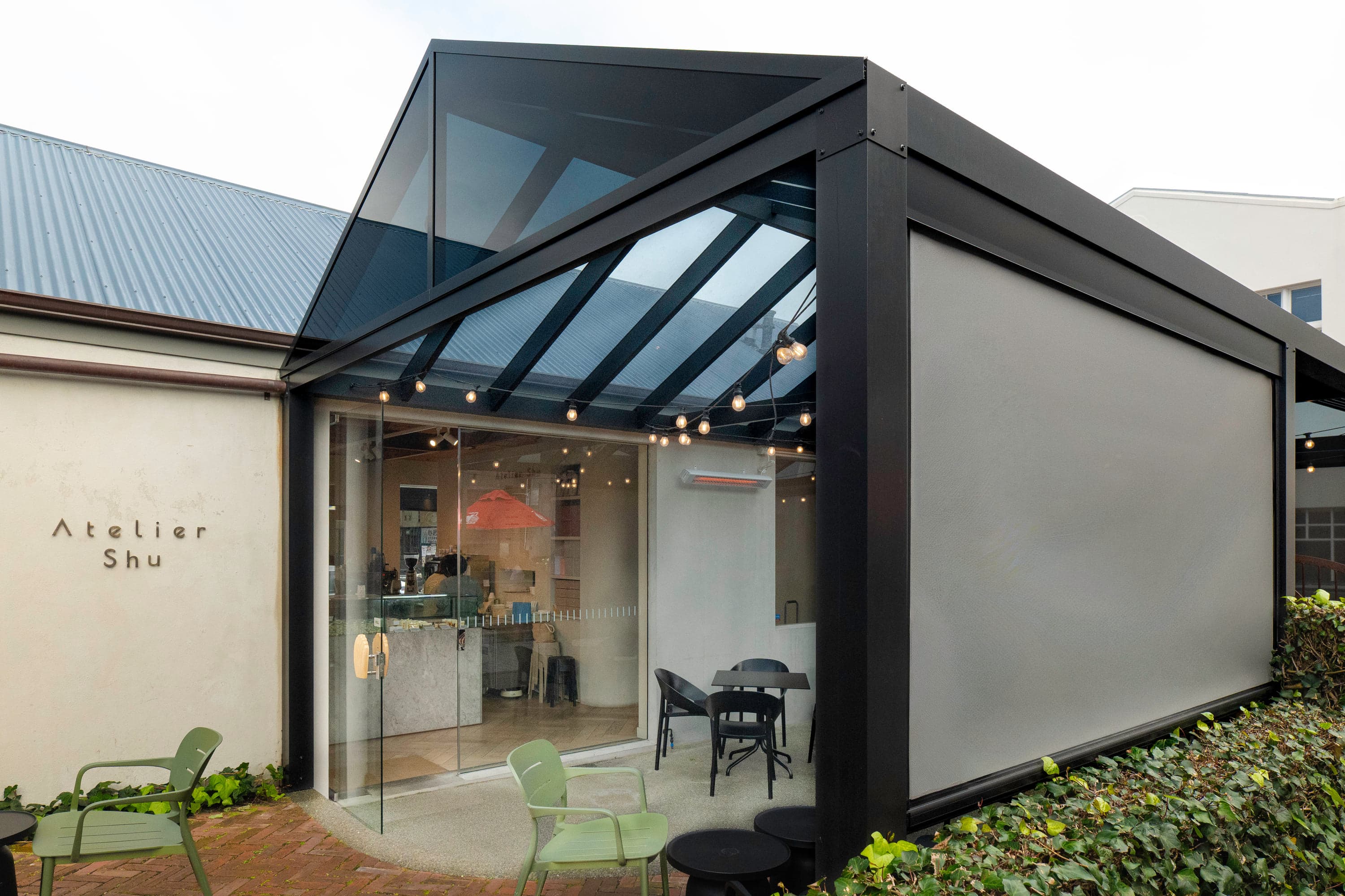 Dark-tint acrylic gable canopy and integrated blinds at Atelier Shu Cafe in Newmarket