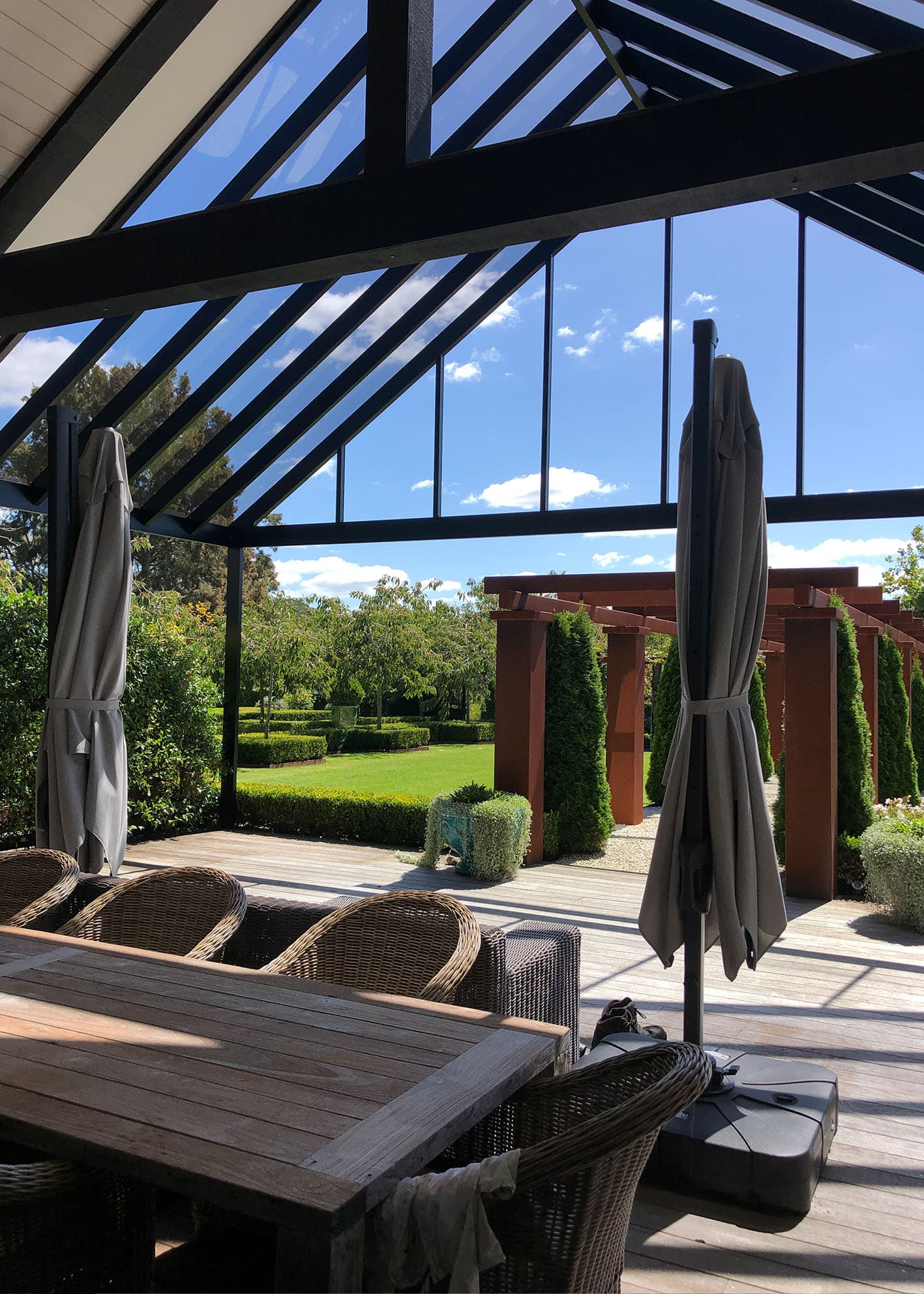 Custom aluminium pergola connection and roof form beside an Auckland home