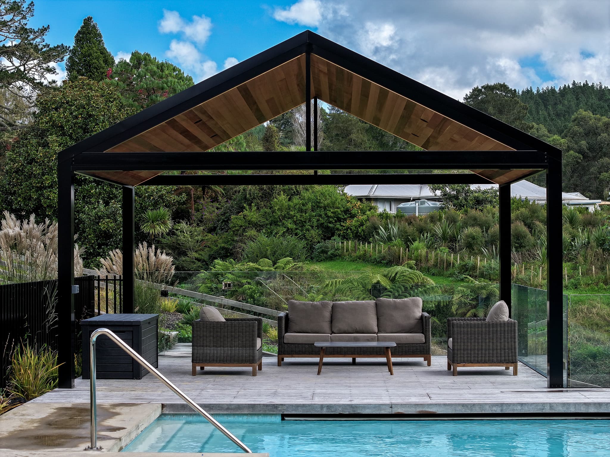 Riverhead gable pavilion with black frame and sheltered seating beside the pool