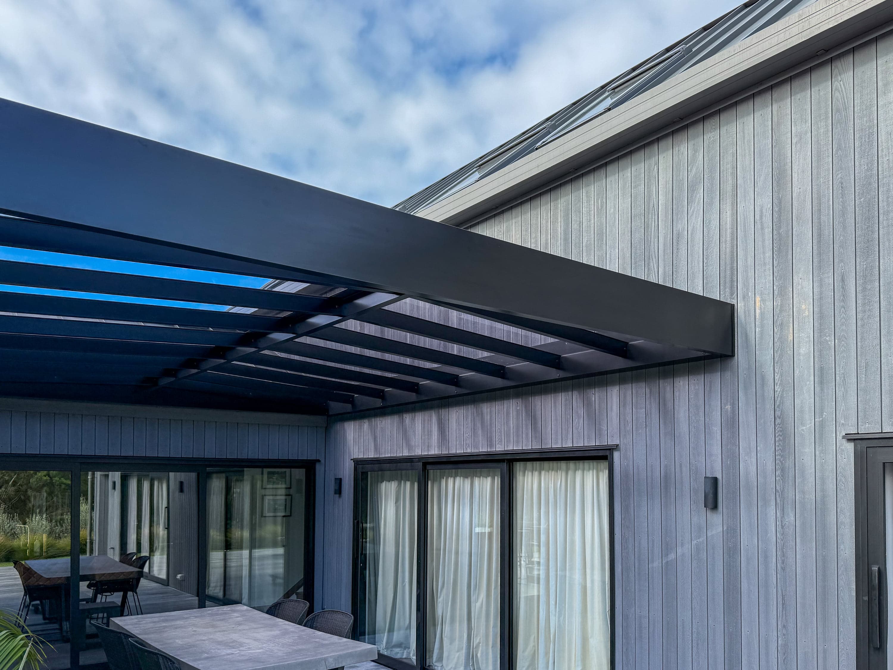 Box-perimeter pergola extending a coastal deck on Waiheke Island