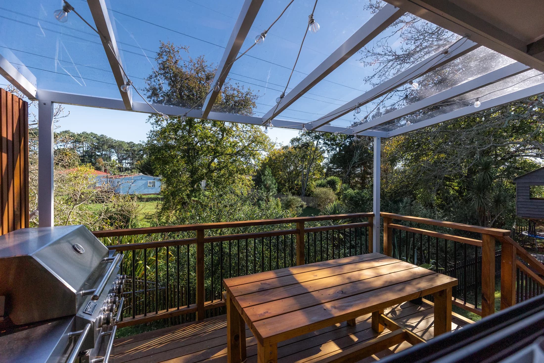 Clear acrylic roof over an elevated deck with a garden outlook